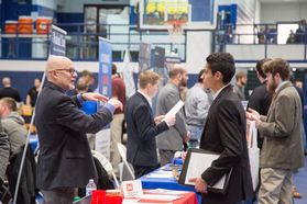 Students talk with potential employer at career fair